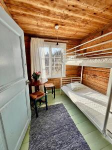 a room with two bunk beds and a table at Ahtelan torppa 1 in Salo