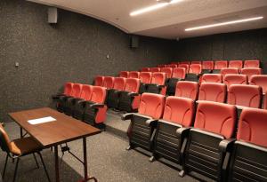 an empty room with red chairs and a table at Park Hotel Porto Aeroporto in Maia