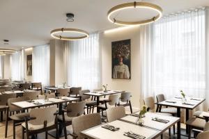a dining room with tables and chairs and windows at Radisson Blu Royal Hotel, Helsinki in Helsinki