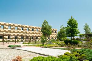 a building with a garden in front of it at Park Hotel Porto Aeroporto in Maia