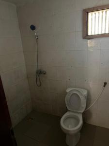 a bathroom with a toilet and a shower at Room 11 in Kololi