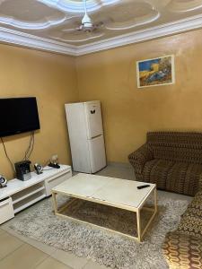 a living room with a couch and a refrigerator at Room 11 in Kololi