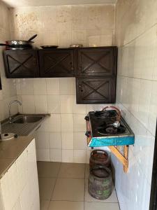 a small kitchen with a stove and a sink at Room 11 in Kololi +3 photos