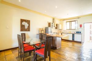 a kitchen and dining room with a table and chairs at Beat's Hideaway in Galu