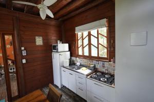 a kitchen with a white refrigerator and a sink at Casa alquiler en Bombas Bombinhas in Bombas