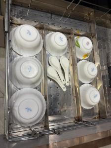 a bunch of white plates and utensils in a drawer at Hotel Namaste With Jacuzzi in Ghaziabad