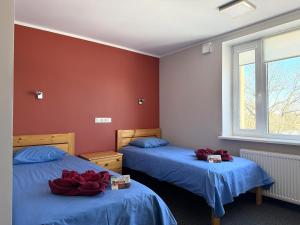 two beds in a room with red walls at Kuremaa Külalistemaja in Kuremaa