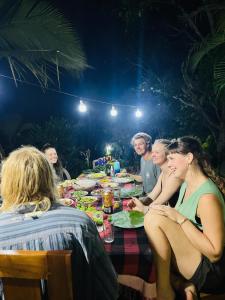 a group of people sitting around a table eating at Mountain Breeze Inn Midigama in Midigama East