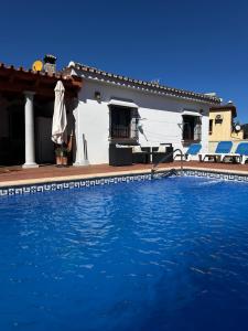a house with a swimming pool in front of it at Chalet vacacional con piscina privada in Arriate