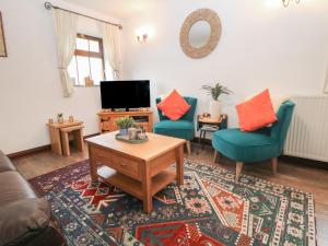 a living room with two chairs and a coffee table at Win Hill View Cottage in Hope