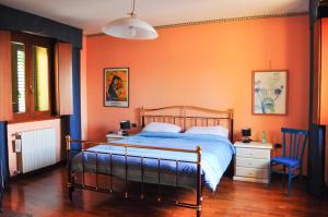 a bedroom with a bed with an orange wall at Il Glicine in Làconi +31 photos