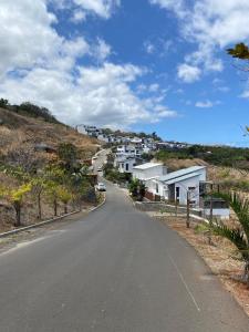an empty road with houses on a hill at le paradis vert bleu in Saint-Paul