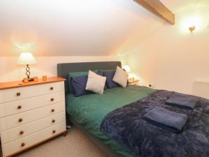 a bedroom with a bed and a dresser at Win Hill View Cottage in Hope