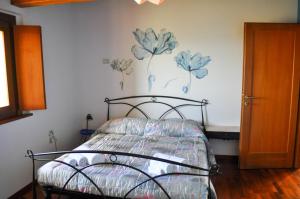 a bedroom with a bed with flowers painted on the wall at Il Glicine in Làconi