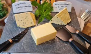 a block of cheese on a cutting board with a knife at Hubertus am Thumsee - Ruhe Frühstück und Alpenpanorama in Bad Reichenhall +52 photos