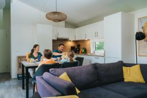 a family sitting at a table in a living room at Moulin de Hotton in Hotton