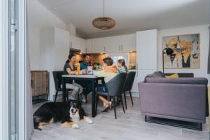 a group of people sitting at a table with a dog at Moulin de Hotton in Hotton