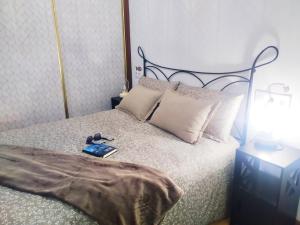 a bedroom with a bed with a book on it at La CASINA de HUGO con Terraza in Luanco