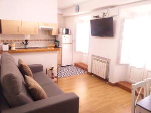 a living room with a couch and a kitchen at La CASINA de HUGO con Terraza in Luanco