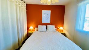 a bedroom with a bed and two lamps on tables at Casa Amarante - Piscine privée chauffée - Climatisation - WIFI in Roquefort-des-Corbières