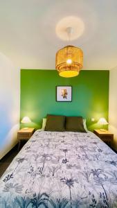 a bedroom with a large bed with a green wall at Casa Amarante - Piscine privée chauffée - Climatisation - WIFI in Roquefort-des-Corbières