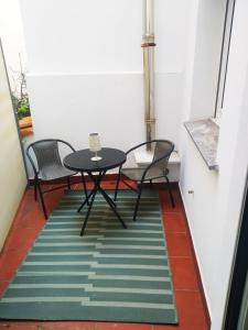 a small table and two chairs on a balcony at La CASINA de HUGO con Terraza in Luanco
