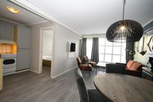 a living room with a dining room table and a kitchen at Bergo Leiligheter in Beitostøl