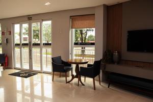 a living room with a table and chairs and a television at Premier Pallace Hotel in Araguaína
