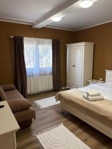 a bedroom with a bed and a cabinet and a window at Studio Sunrise in Sinaia