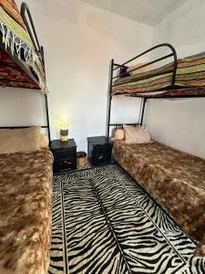 a room with two bunk beds and a zebra rug at Rhythm House in Essaouira