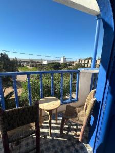 a patio with two chairs and a table on a balcony at Rhythm House in Essaouira