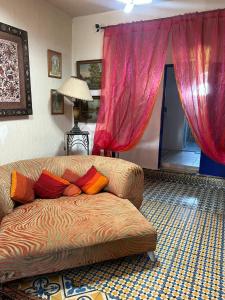 a living room with a couch and red curtains at Rhythm House in Essaouira