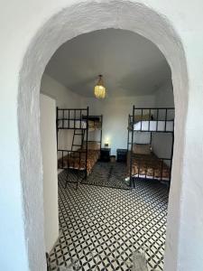 a room with three bunk beds and an archway at Rhythm House in Essaouira +1 photo
