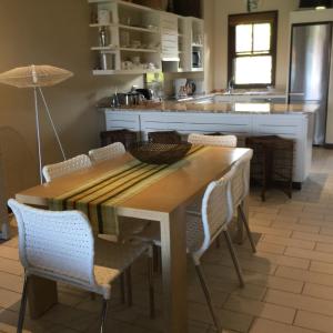 a kitchen with a wooden table and chairs at Eden Island Apartment 70A14 in Eden Island