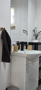 a white bathroom with a sink and a mirror at Domki u Sołtysa in Ciechocinek