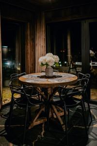 a wooden table with a vase of flowers on it at Na Gorczańskim Wierchu Chalet, basen, sauna, balia na wyłączność in Rabka-Zdrój