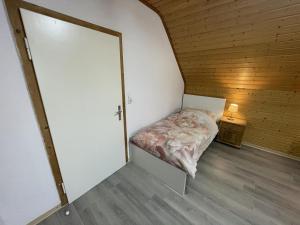 a small bedroom with a bed in a wooden room at Schicke Ferien- und Monteurswohnung 53 qm Philippsburg in Philippsburg +21 photos