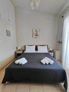 a bedroom with a bed with two towels on it at Golden Horizon Haven in Preveza