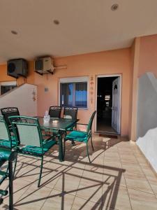 a patio with a table and chairs and a television at Golden Horizon Haven in Preveza
