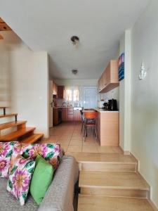 a living room with a couch and a kitchen at Golden Horizon Haven in Preveza
