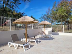 two chairs and two umbrellas on a patio at Le Mas Cauvy in Saint-Christol-lès-Alès +14 photos