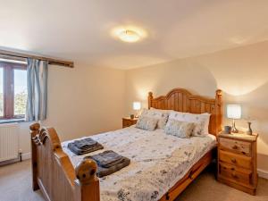 a bedroom with a wooden bed with two lamps and a window at 3 Bed in Bude oc-corym in Morwenstow +15 photos