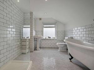 a bathroom with a tub and a toilet and a sink at 3 Bed in Newquay oc-53688 in Newquay +25 photos