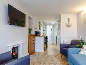 a living room with a fireplace and a tv at 2 Bed in Polruan oc-82949 in Fowey
