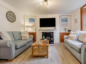 a living room with two couches and a fireplace at 2 Bed in Wadebridge oc-83130 in Little Petherick