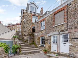 an old brick house with a white door and stairs at 2 Bed in Polruan oc-82949 in Fowey