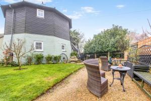 a backyard with a table and chairs and a house at Hunston Mill Self Catering Dog Stay For Free in Chichester +71 photos