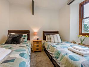 a bedroom with two beds next to a window at 2 Bed in Wadebridge oc-83130 in Little Petherick