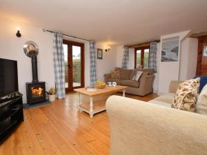 a living room with a couch and a fireplace at 2 Bed in Bude oc-coryw in Morwenstow
