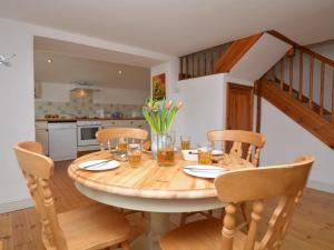 a kitchen and dining room with a wooden table and chairs at 2 Bed in Bude oc-coryw in Morwenstow
